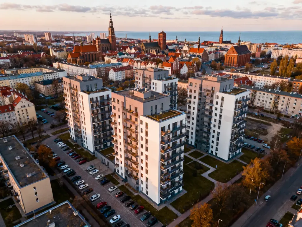 Nowoczesne osiedle mieszkaniowe w Gdańsku na tle panoramy miasta i morza, symbolizujące aktualne ceny i rozwój rynku no text on the picture